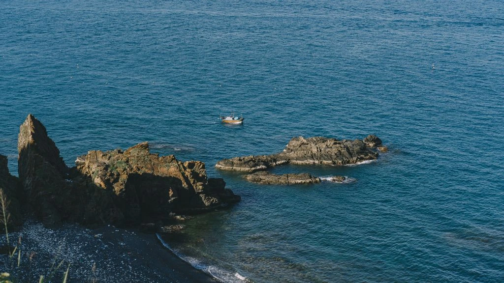 A quiet coastal village at dawn with a single wooden boat.